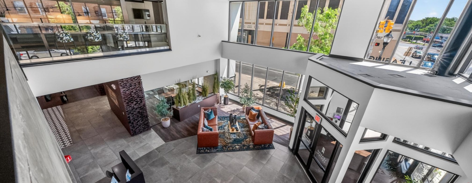 Bird eye view of lobby area from the 2nd floor showing view of entrance, seating, and conference room