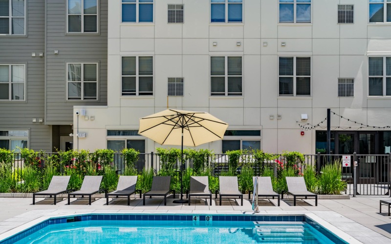 Pool deck with lounge seating and umbrella