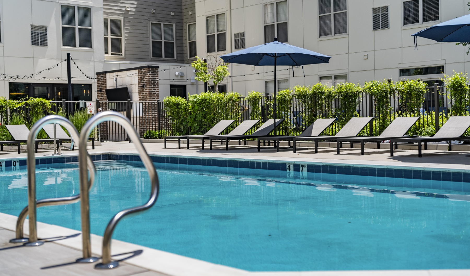 Pool deck with lounge seating, umbrella, and a swimming pool